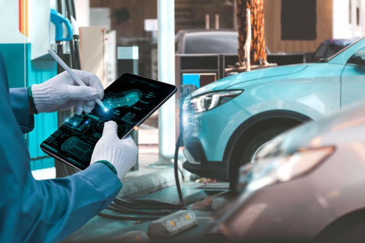 Electric car with person holding tablet looking through graphics
